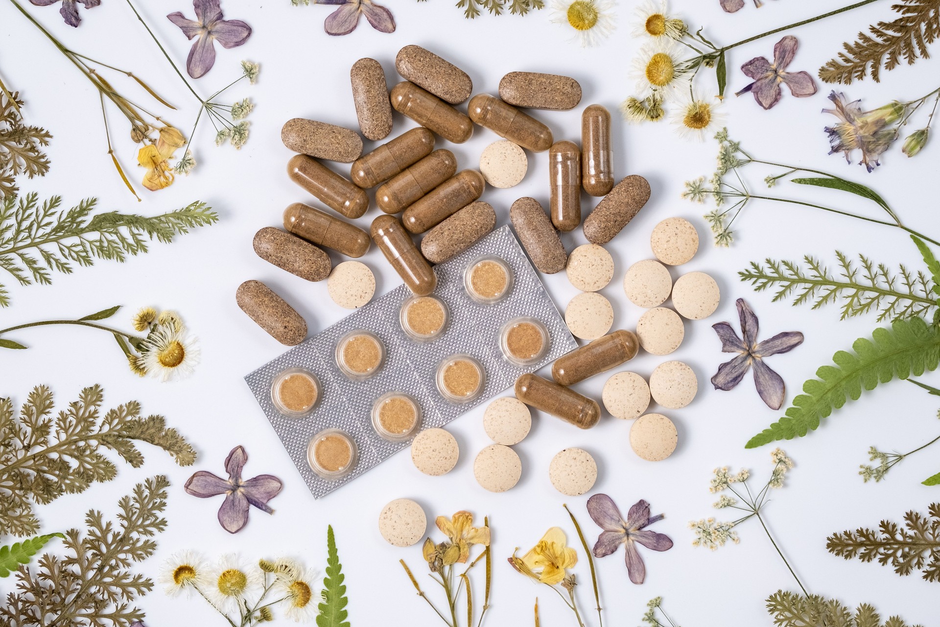 Herbal medicine in capsules for healthy eating concept with organic herb. Natural alternative medicine. Herbal supplements and dried medicinal herbs, top view, flat lay. Herbal extract medicine tablets pills